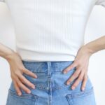 両手を腰に当てる女性