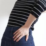 腰に手を当てるボーダー柄の女性