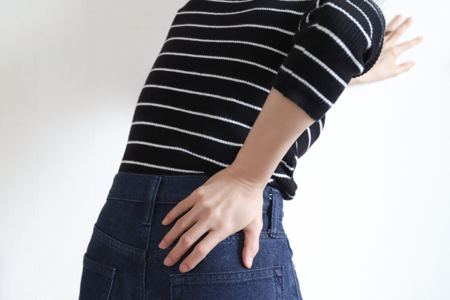 腰に手を当てるボーダー柄の女性